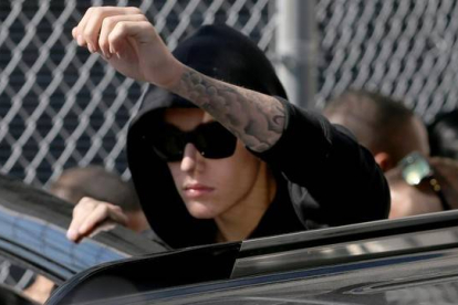 Justin Bieber saluda a sus fans a la salida del correccional.