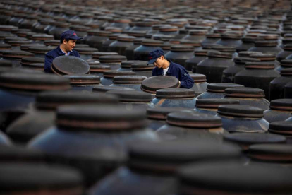 Dos empleados revisan barriles de vinagre en una de las fábricas de Zhenjiang. ALEX PLAVEVSKI
