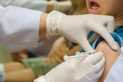 Una enfermera pone una vacuna a un niño.