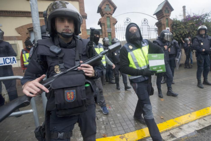 Agentes de la Policía Nacional retiran material del Instituto Can Vilumara de L'Hospitalet de Llobregat.