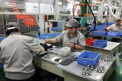 Trabajadores ensamblan chips y otros componentes en la empresa tecnológica Yaguang, en la ciudad sureña de Guiyang, China.