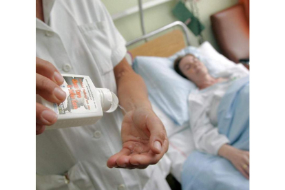 Una enfermera atiende a una paciente en un hospital de la Seguridad Social.