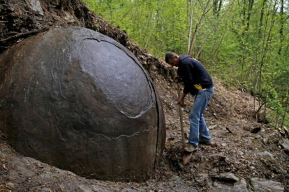 Suad Keserovic limpia la esfera de piedra en Podubravije, cerca de Zavidovici (Bosnia), el 11 de abril.