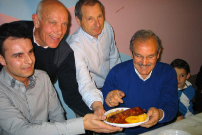 Prada, con bigote, con los organizadores del evento gastronómico, sujetando una androlla con patatas.