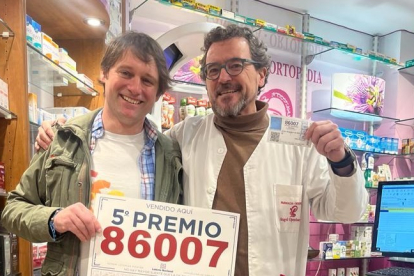 El vendedor, Raúl Fuertes, con el comprador del décimo premiado en Veguellina, Ángel Ojembarrena. DL