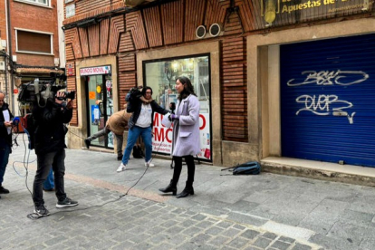 Un equipo de televisión ante el cierre bajado de la administración número 3 de la calle Padre Tomás Lozano, en Teruel, que ha vendido íntegramente el primer número premiado en el sorteo de la Lotería de Navidad, el 54.274, uno de los quintos premios, que suponen en total 11,1 millones de euros. EFE
