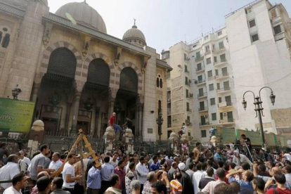 Simpatizantes de los Hermanos Musulmanes y policías, ante la mezquita de El Cairo donde se han atrincherado los islamistas, este sábado.
