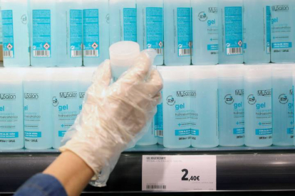 Una mujer compra gel de manos en un supermercado en Madrid. RODRIGO JIMÉNEZ