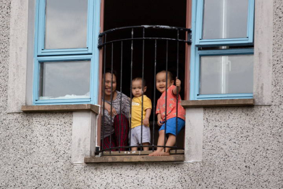 Una familia se asoma al balcón de su casa en Glasgow. ROBERT PERRY