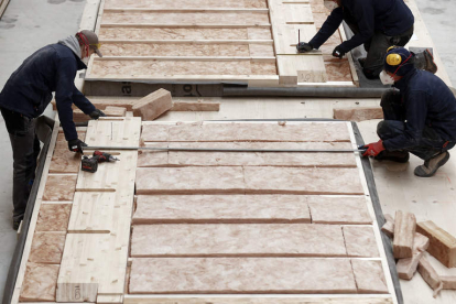 Varios trabajadores terminan de elaborar una pared de madera para su uso. JESÚS DIGES