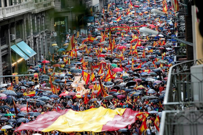 Varios participantes portan la bandera española durante la manifestación convocada por Movimiento Cívico de España y Catalanes, hoy por la Vía Layetana, en Barcelona.