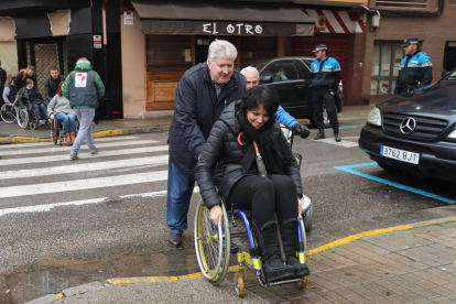 El concejal Ricardo Miranda, ayer, llevando en silla de ruedas a Rosa Luna. L. DE LA MATA