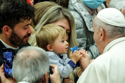 El papa le pone el chupete a un bebé, durante la celebración ayer de la audiencia semanal en el Vaticano. GIUSEPPE LAMI