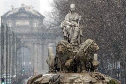 Imagen de la Cibeles, con la Puerta de Alcalá al fondo, mientras nevaba por la mañana