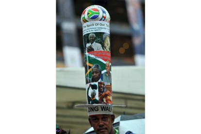 Un hombre con uno de los peculiares sombreros de homenaje a Mandela que se pueden ver en la ceremonia. ALEXANDER JOE | AFP