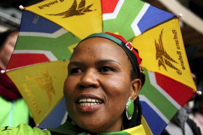 Una mujer con un sombrero-paraguas con los colores sudafricanos, asiste al evento. SIPHIWE SIBEKO | REUTERS