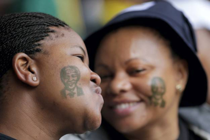 Tatuajes de Mandela adornan los rostros de dos chicas asistentes a la ceremonia. Bernat Armangue | AP