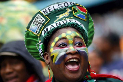 Sombreros y pinturas multicolores, entre los asistentes al funeral de Mandela. KAI PFAFFENBACH | REUTERS