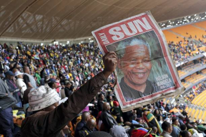 Un hombre sostiene una foto de Mandela, en el estadio FNB. Bernat Armangue | AP