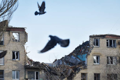 Unas palomas vuelan frente a los restos de un bloque de casas en la ciudad ucraniana de Bajmut. OLEG PETRASYUK