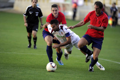 Murci, autor del único gol leonés, se zafa de dos defensas de La Granja, en un lance del partido.