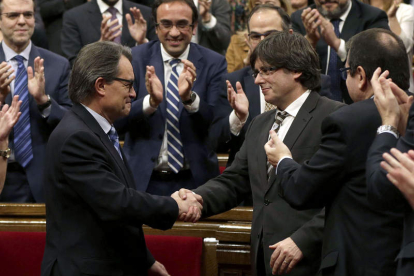 Mas y Puigdemont se dan la mano una vez concluida la sesión de investidura.