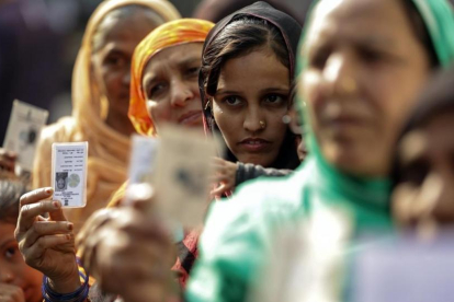 Varias mujeres hacen cola en un colegio electoral durante la segunda fase de las elecciones para la Asamblea estatal de Gujarat, en Ahmedabad (India), el 14 de diciembre.
