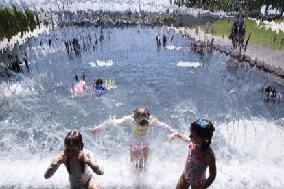 Niños bañándose ayer en un parque de un barrio de Washington. MICHAEL REYNOLDS
