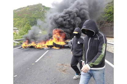 Dos mineros pasean ante la barricada en Ciñera de Gordón. Ramiro