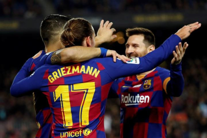 Antoine Griezmann celebra con sus compañeros, Luis Suárez y Leo Messi su gol ante el RCD Mallorca. TONI ALBIR