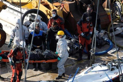 Miembros de los servicios de rescate recuperan el cuerpo de una de las victimas mortales del barco naufragado en el río Danubio.