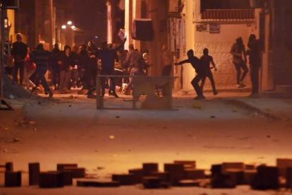 Manifestantes lanzan piedras contra las fuerzas de seguridad en el distrito de Djebel Lahmer, en Túnez, el 10 de enero.