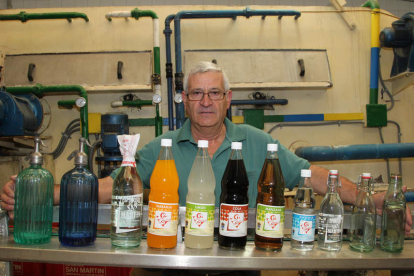 Sobre estas líneas, en la primera fotografía, Luis San Martín posa junto a una decena de botellas históricas de gaseosa. Debajo, Aniceto López, en su fábrica de Quintana de Fuseros.