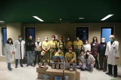 Los bomberos forestales de León, con base en Sahechores, han llevado regalos a los niñños del Caule gracias a una iniciativa solidaria encauzada por la Asociación Sonrisas. HOSPITAL DE LEÓN