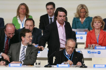 José María Aznar pasa por el lado de Mariano Rajoy, sentado junto a Manuel Fraga, en la clausura del XVI congreso nacional del PP, en el 2008 en Valencia