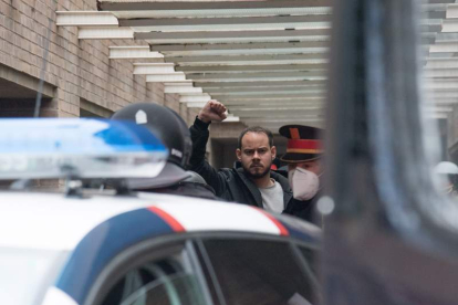 Hasél levanta el puño tras su detención. Activistas vacían los extintores para impedir el acceso de los mossos. RAMÓN GABRIEL / PAU DE LA CALLE