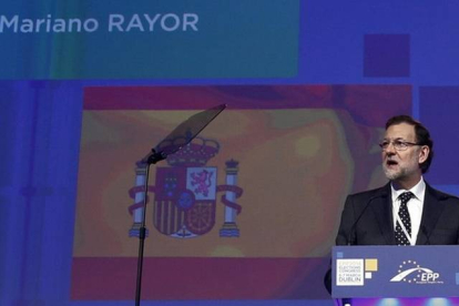 El presidente del Gobierno español, Mariano Rajoy, con la pantalla de fondo donde aparece su apellido mal escrito.
