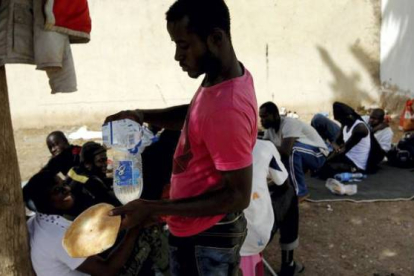 Uno de los inmigrantes se prepara algo de comida. Foto: JOSE LUIS ROCA / Oudja