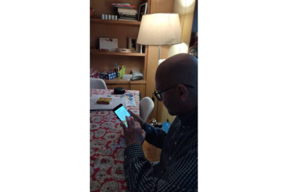 José González Fernández, Xose, en su casa escribiendo en leonés en su teléfono móvil para subir el texto a las redes sociales.