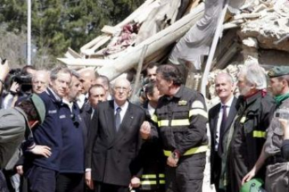 El presidente italiano, Giorgio Napolitano, en el centro, observa  los destrozos junto a unos bomber
