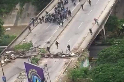 La policía venezolana irrumpe, en motos, para dispersar una manifestación.