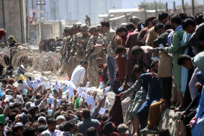 Miles de afganos muestran credenciales mientras buscan contactar con las fuerzas internacionales para intentar huir del país. AKHTER GULFAM