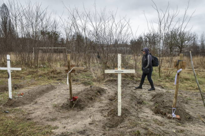 Un ciudadanos pasa por un cementerio local  en Kiev), Ucrania. OLEG PETRASYUK