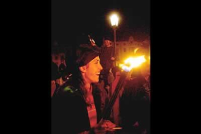 Una joven disfruta del tradicional entierro de Genarín, una procesíón pagana que se celebra la noche del Jueves Santo y que recorre las calles de León con un particular paso.