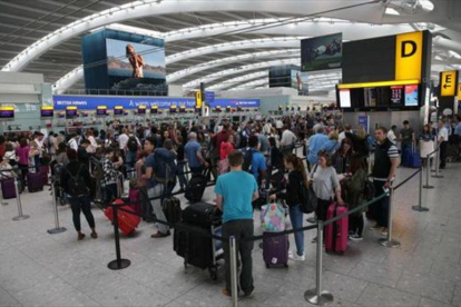 Colas de pasajeros originadas por el fallo informático, en la terminal 5 del aeropuerto inglés de Heathrow, ayer.