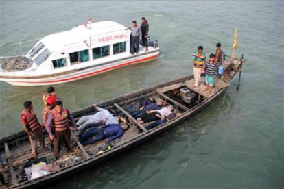 Los equipos de emergencia, rescatan a pasajeros del ferri, tras la colisión, este domingo, en el río Padma, en Bangladesh.