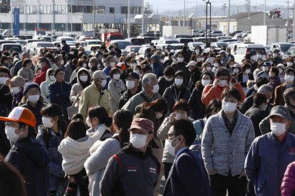 Gente haciendo cola junto a la antorcha olímpoca eb Iwaki, Fukushima, después de conocer la decisión de posponer los Juegos Olímpicos. KIMIMASA MAYAMA