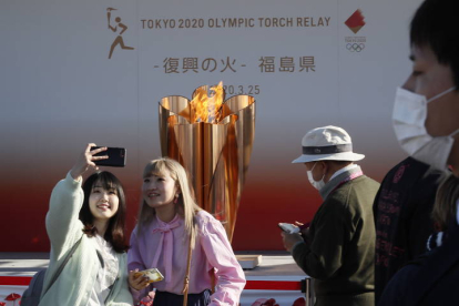 Dos mujeres se hacen una foto junto a la antorcha olímpica en Iwaki, Japón. KIMIMASA MAYAMA