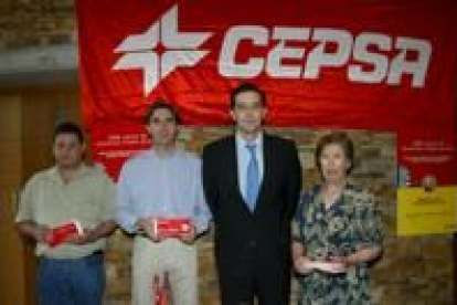 El director de gasóleos de Cepsa, de traje en el centro, junto a los tres premiados
