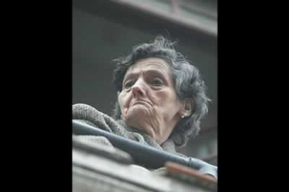 Una señora contempla desde un balcón del Barrio Húmedo el transcurso de la procesión.